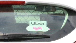 Uber and Lyft stickers on a car