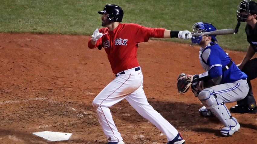 Boston Red Sox's J.D. Martinez watches the flight of his two-run home run during the fifth inning of an exhibition baseball game against the Toronto Blue Jays, Tuesday, July 21, 2020, at Fenway Park in Boston.