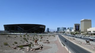 Construction continues at Allegiant Stadium, the USD 2 billion, glass-domed future home of the Las Vegas Raiders, west of a marquee at Mandalay Bay Resort and Casino displaying the message "Shoes On Shirt On Mask On Vegas On" after the Las Vegas Strip property opened for the first time since being closed in mid-March because of the coronavirus (COVID-19) pandemic on July 1, 2020 in Las Vegas, Nevada.