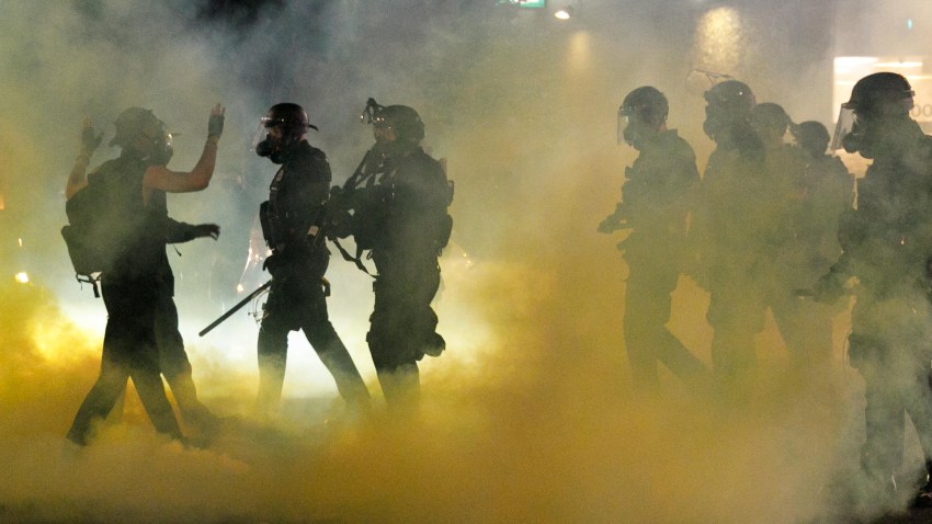In this July 4, 2020, file photo, police confront demonstrators as Black Lives Matter supporters demonstrate at Portland's Justice Center in Portland, Oregon, for the 38th day in a row. A riot was declared after midnight.