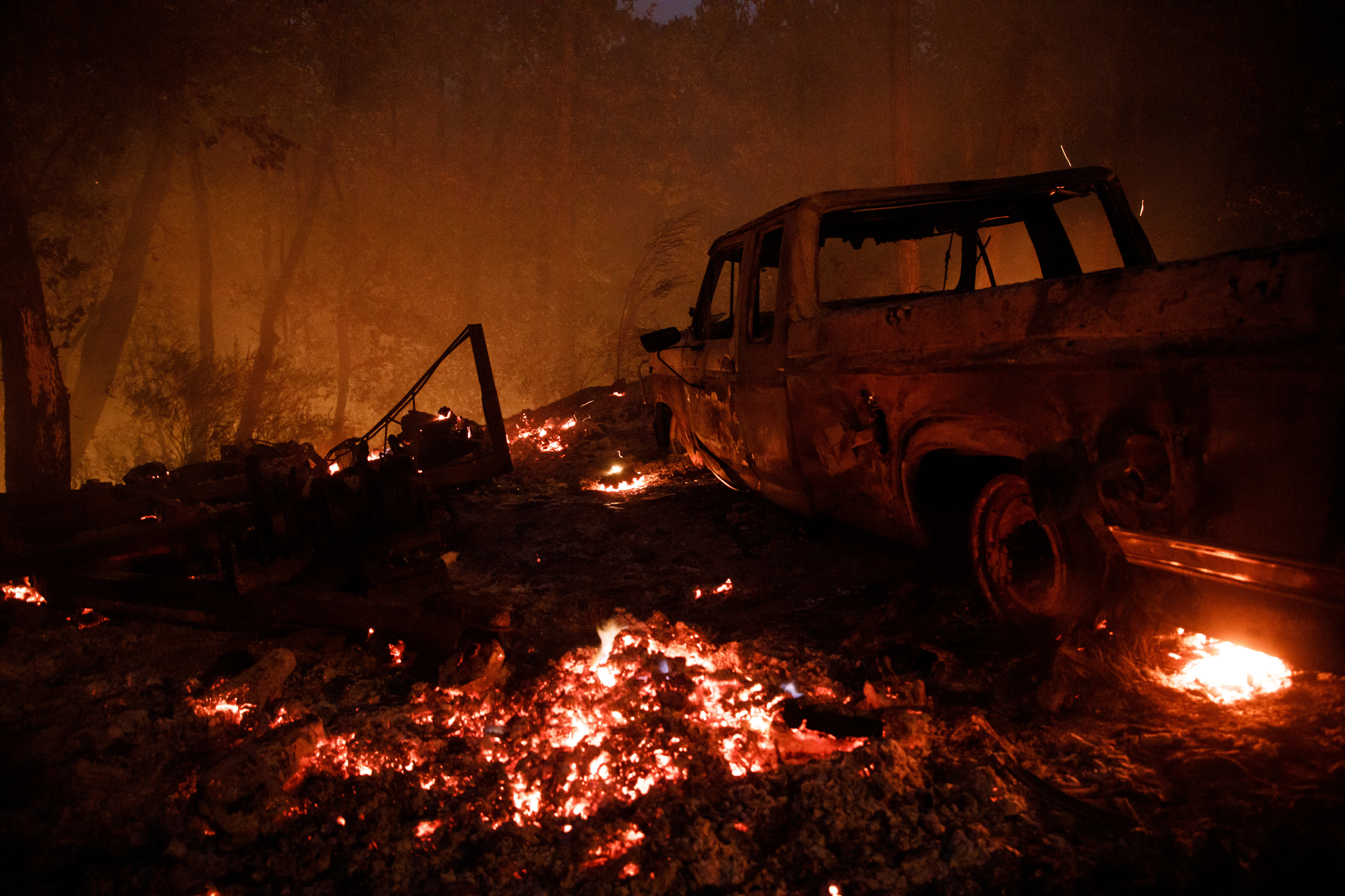 A burned-out vehicle is seen on Hillside Way on Aug. 21, 2020, in Boulder Creek, Calif., as the CZU August Lightning Complex fire burns in the Santa Cruz Mountains.