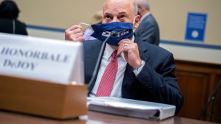 Postmaster General Louis DeJoy removes his face mask as he arrives to testify before a House Oversight and Reform Committee hearing on the Postal Service on Capitol Hill, Monday, Aug. 24, 2020, in Washington.