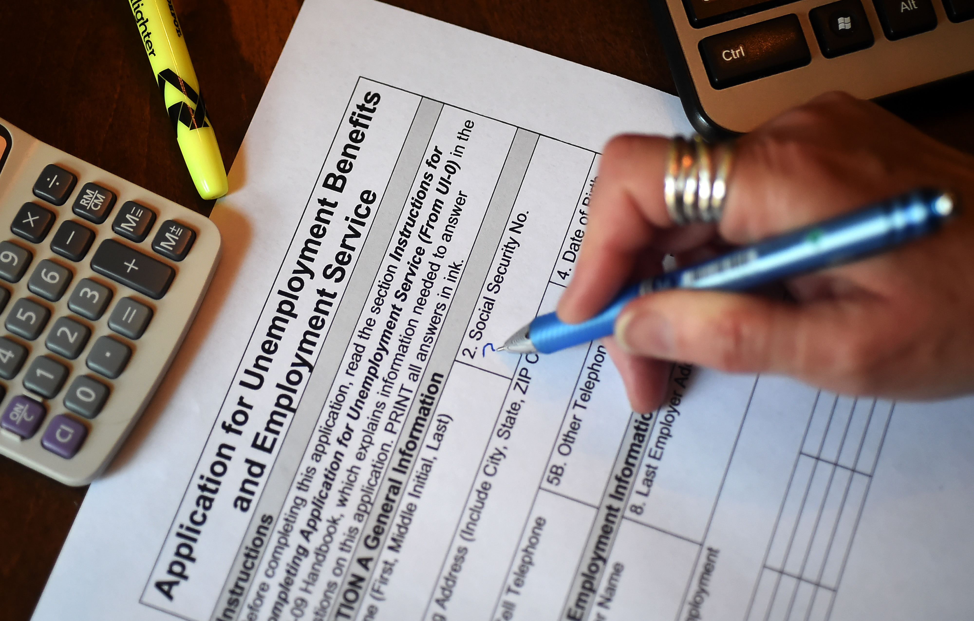 In this April 16, 2020, photo illustration, a person files an application for unemployment benefits in Arlington, Virginia.