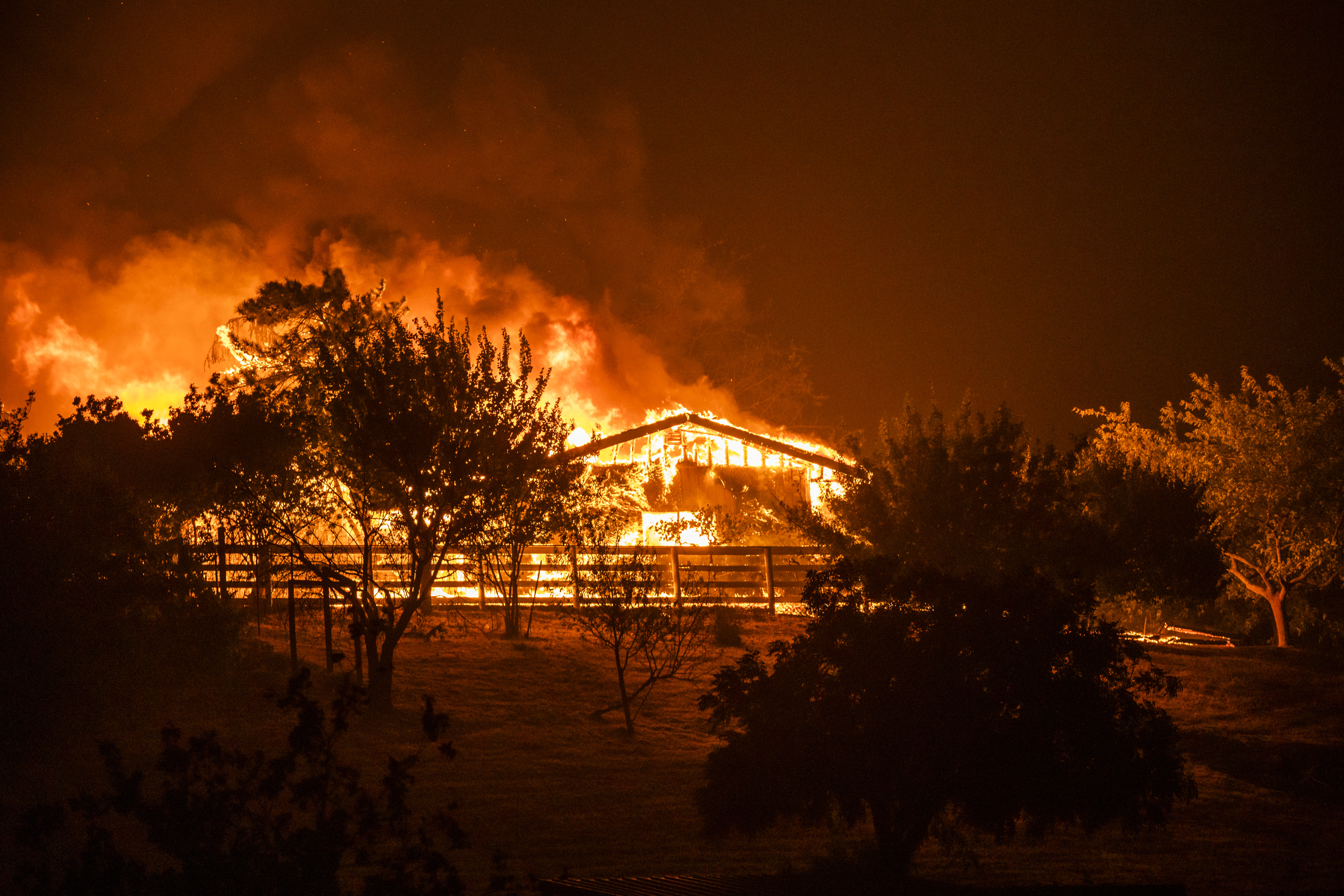 A home burns along Peaceful Glen Road during the Hennessy fire in Solano County, California, U.S., on Wednesday, Aug. 19, 2020. More Northern Californians were chased out of their homes by lightning-sparked wildfires that burned out of control in several counties amid a punishing heat wave that pushed temperatures into the triple digits. Photographer: Philip Pacheco/Bloomberg via Getty Images