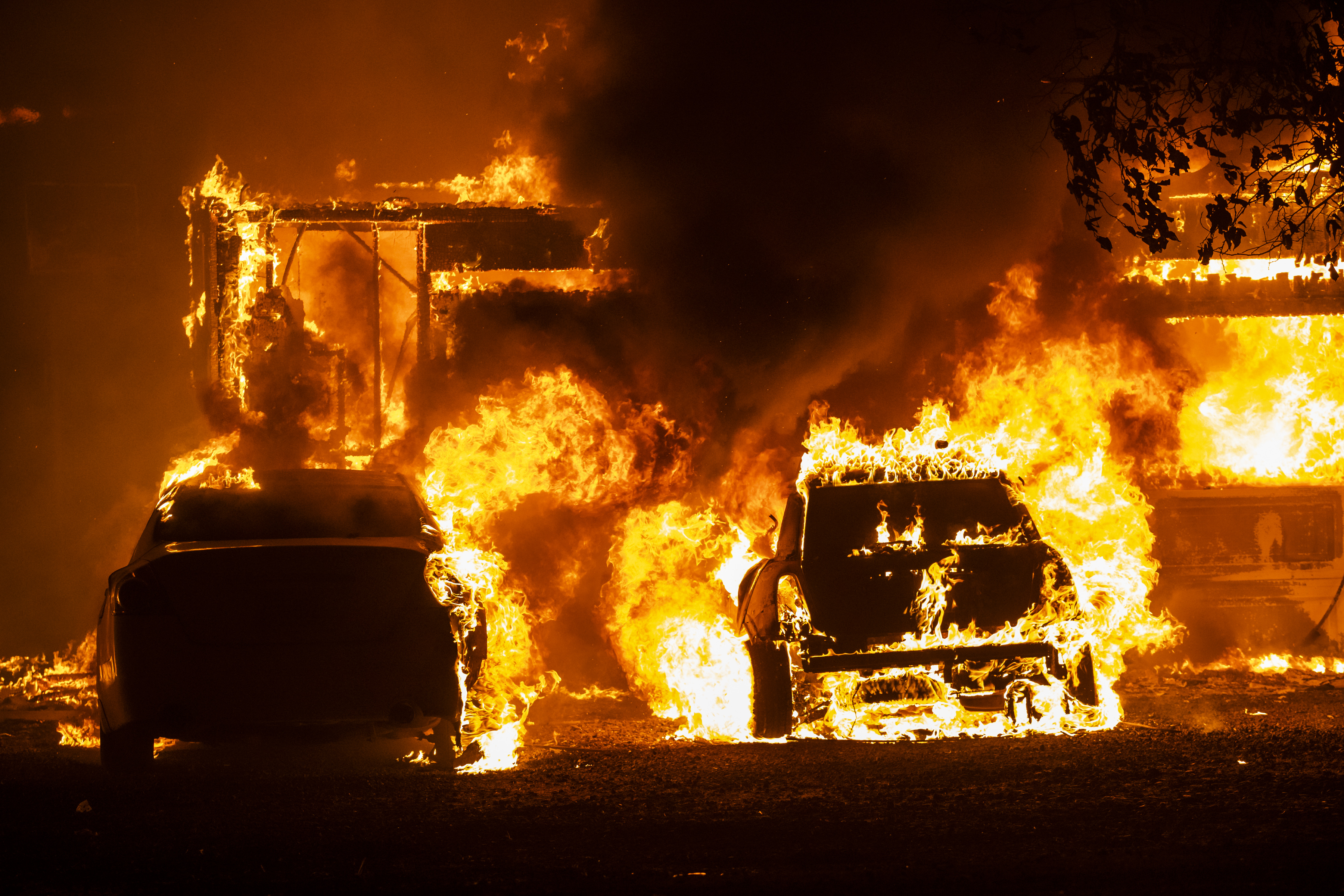 Vehicles catch fire in front of a burning home along Peaceful Glen Road during the Hennessy fire in Solano County, California, U.S., on Wednesday, Aug. 19, 2020. More Northern Californians were chased out of their homes by lightning-sparked wildfires that burned out of control in several counties amid a punishing heat wave that pushed temperatures into the triple digits. Photographer: Philip Pacheco/Bloomberg via Getty Images
