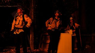 BOULDER CREEK, CA – AUGUST 23: Firefighters respond to a structure fire along Riverdale boulevard as the fire line creeps up on Highway 9 during the CZU Lightning complex fire on Sunday, Aug. 23, 2020 in Boulder Creek, CA (Kent Nishimura / Los Angeles Times via Getty Images)