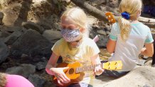 young girl strumming ukulele