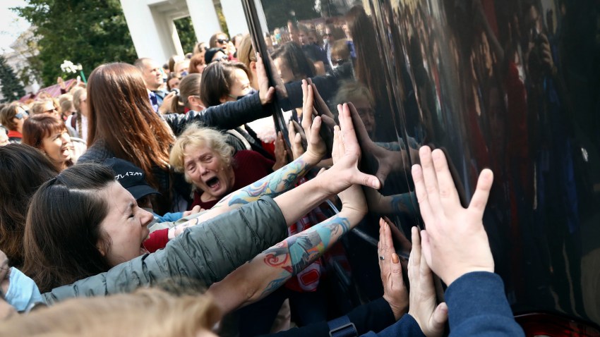 Women block a police bus during an opposition rally to protest the official presidential election results in Minsk, Belarus