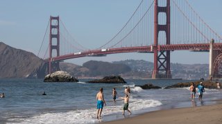 People cool off on Baker Beach in San Francisco.