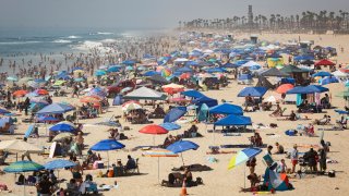 People escape the California heat wave at the beach, Sunday, Sept. 6, 2020, in Huntington Beach, Calif.