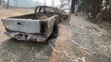 A burned up truck with melted aluminum hubcaps shows the intensity of the fire.