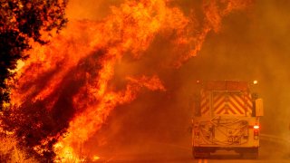 A fire truck drives through flames as the Hennessey fire continues to rage.