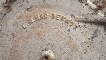 The front smoke box of a burned locomotive is stamped with the name of its maker, Louis MacDermot, who built the railway for the 1915 Pan Pacific International Exposition.