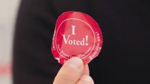circular red sticker that says "I voted"