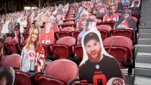 large cut-out photos of fans sit in red stadium seats