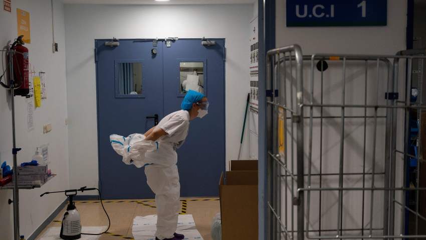 A healthcare worker takes off her protective suit after attending to coronavirus patients at the Intensive Care Unit (ICU) of the Severo Ochoa University Hospital in Leganes on October 16, 2020.