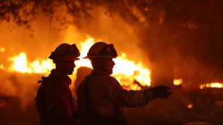 Firefighters battle the Glass Fire on October 01, 2020 in Calistoga, California. The fast moving Glass Incident Fire, originally called the Glass Fire, has burned 56,000 acres in Sonoma and Napa counties and has destroyed numerous wineries and structures. The fire is five percent contained.