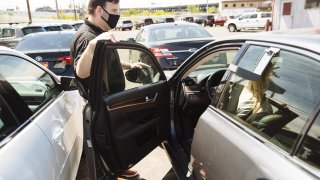 A car dealer shows a vehicle to customers at a dealership in Jersey City, New Jersey.