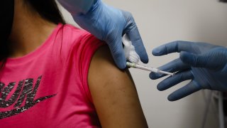 A health worker injects a person during clinical trials for a Covid-19 vaccine at Research Centers of America in Hollywood, Florida.