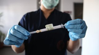 A health care worker holds an injection syringe of the phase 3 vaccine trial, developed against the novel coronavirus (COVID-19) pandemic by the U.S. Pfizer and German BioNTech company, at the Ankara University Ibni Sina Hospital in Ankara, Turkey on October 27, 2020.