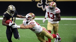 Deonte Harris of the New Orleans Saints breaks a tackle from Daniel Heim of the San Francisco 49ers.