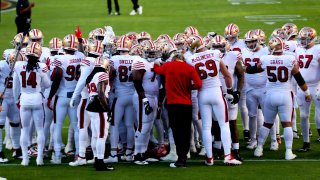 The San Francisco 49ers huddle on the field.