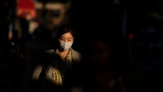 A woman wearing a face mask walks along the street in the Hollywood section of Los Angeles, Thursday, Nov. 12, 2020. California has become the second state to record 1 million confirmed coronavirus infections. (AP Photo/Jae C. Hong)