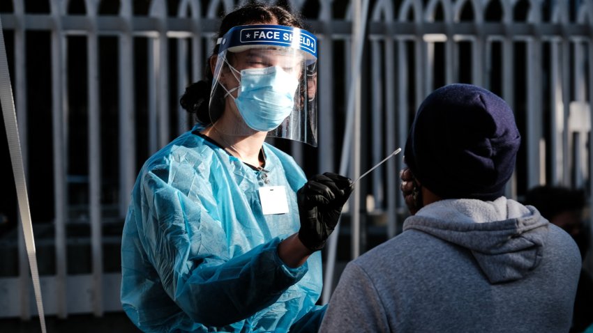 A healthcare worker administers a test at a Covid-19 testing tent outside a Bay Area Rapid Transit (BART) station.