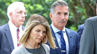 In this Aug. 27, 2019, file photo, actress Lori Loughlin and her husband Mossimo Giannulli leave Moakley Federal Courthouse after a brief hearing in Boston, Massachusetts.
