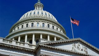 In this file photo, the stars and stripes flag flies at the Capitol Building in Washington, D.C.