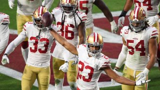 Cornerback Ahkello Witherspoon of the San Francisco 49ers celebrates with teammates after intercepting the ball.