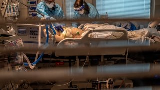 Phlebotomist lab assistant Jennifer Cukati, right, and Registered Nurse Carina Klescewski, left, care for a COVID-19 patient inside the Sutter Roseville Medical Center ICU in Roseville, Calif., on Tuesday, Dec. 22, 2020.