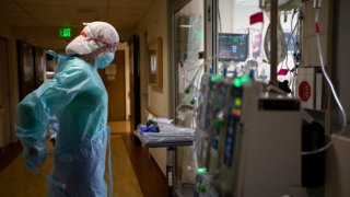 Registered Nurse Joan Pung, right, dawns her isolation gowns in the hallway inside the ICU at Providence St. Jude Medical Center Christmas Day on Friday, Dec. 25, 2020 in Fullerton, CA.