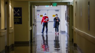 SAN FRANCISCO, CA – JUNE 24: Rodney Garrick and Jennifer Carton-Wade (right) walk down the hallway at Laguna Honda hospital on Wednesday, June 24, 2020 in San Francisco, California. Fears of a widespread coronavirus infection among staff and patients was averted. (Gabrielle Lurie/The San Francisco Chronicle via Getty Images)