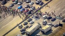 protesters swarm onto a freeway, blocking traffic