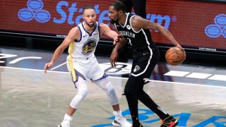 Kevin Durant of the Brooklyn Nets dribbles against Stephen Curry of the Golden State Warriors.