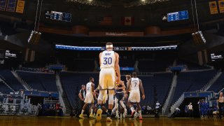 Stephen Curry of the Golden State Warriors stands on the court during a preseason game.