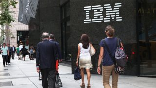 Pedestrians walk in front of the IBM building in New York.