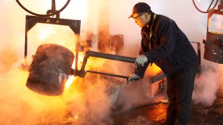A worker pours molten iron into a mold at a mill manufacturing marine engine components in Huaian, Jiangsu province, China February 11, 2019.