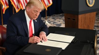 US President Donald Trump signs executive orders extending coronavirus economic relief, during a news conference in Bedminster, New Jersey, on August 8, 2020.