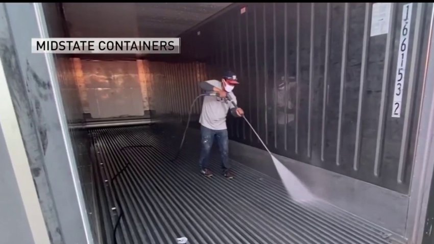 A worker for Mid-State Containers prepares a refrigerated trailer for bodies of COVID-19 victims.