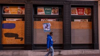 Un hombre camina frente a un restaurante cerrado en Market Street, en San Francisco.