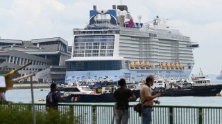 File Photo: The Royal Carribean International cruise ship Quantum of the Seas (C) is docked at Marina Bay Cruise Centre in Singapore on December 9, 2020.