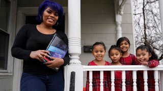 Dinora Torres, a MassBay Community College student, poses with her four daughters on the front porch of their home