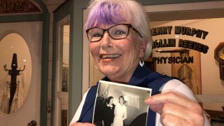 Nurse practitioner Sigrid Stokes, 76, holds a photograph of her mother talking to Shirley Temple, at the Salinas Valley Memorial Hospital in Salinas, California, Feb. 3, 2021.