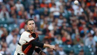 Catcher Buster Posey of the San Francisco Giants fields a bunt and throws to first base.