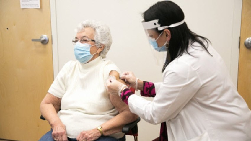 A woman receives a COVID-19 vaccine at a CVS store.