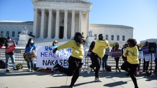 Dancers perform in front of the US Supreme Court in Washington, DC, on November 10, 2020, as the high court opened arguments in the long-brewing case over the constitutionality of the 2010 Affordable Care Act, under which then-president Barack Obama's government sought to extend health insurance to people who could not afford it. - President Donald Trump's outgoing administration took aim in the US Supreme Court Tuesday at razing the "Obamacare" health program his predecessor built, a move which could cancel the health insurance of millions in the middle of the Covid-19 pandemic.