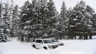 SUVs are parked in the snow.