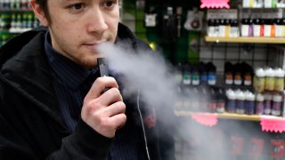 Nick Gregory, a 26-year-old manager, vapes on a JUUL at Botany Bay in Lexington, Ky.